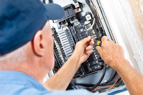 Electrician fixing breakers and wires in panel