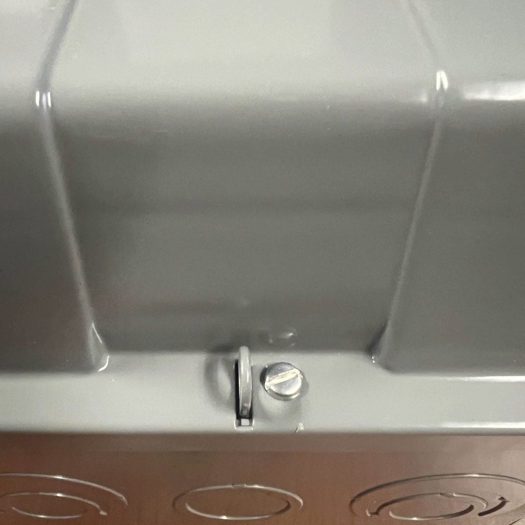 Close-up of a metallic object with a screw on a reflective surface