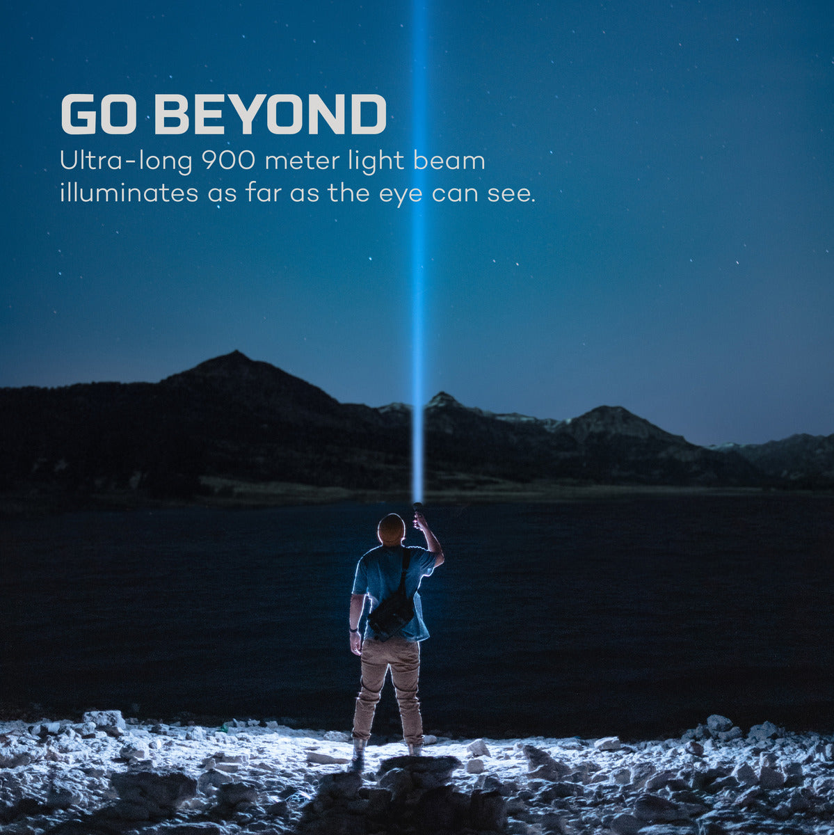 Person holding a flashlight with a long light beam illuminating a dark landscape.