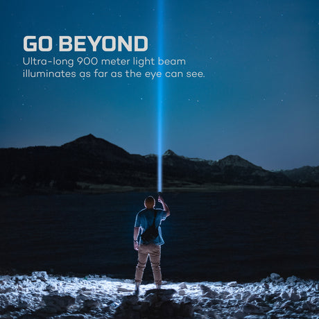 Person holding a flashlight with a long light beam illuminating a dark landscape.