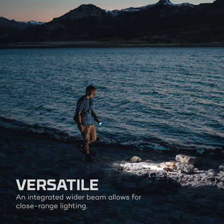 Person walking along a lakeshore with mountains in the background, text overlay 'VERSATILE' and description.